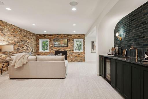 Original brick accent walls paired with a modern beverage bar. Continue to your lower level walk out to the back yard.