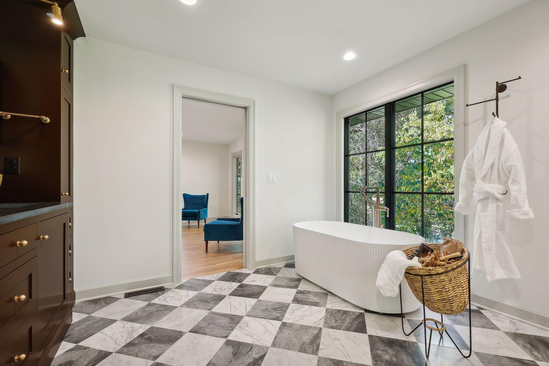 This beautiful primary bath features modern checkered tile floors complemented by warm wood cabinets, creating a chic and inviting atmosphere.