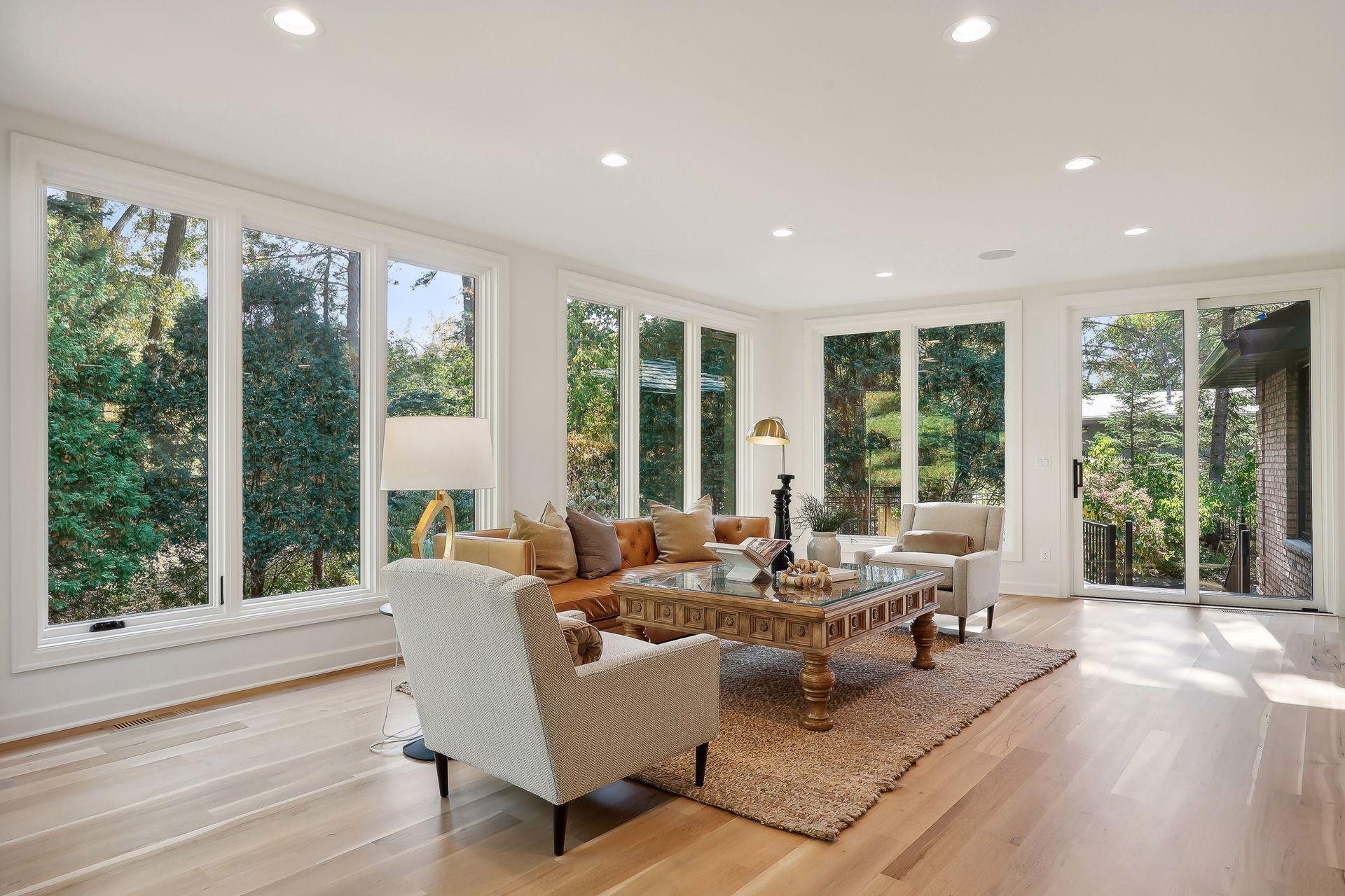 This inviting family room is bathed in natural light, with beams streaming through large windows to create a warm and welcoming atmosphere. Perfect for relaxation and family time, this space combines comfort with a bright, cheerful ambiance.