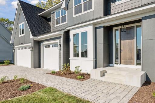 Alt view front elevation with paver driveway and path to front stoop