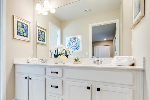 Shared hall bathroom with double vanities. *Photos of model home, finishes and options will vary.