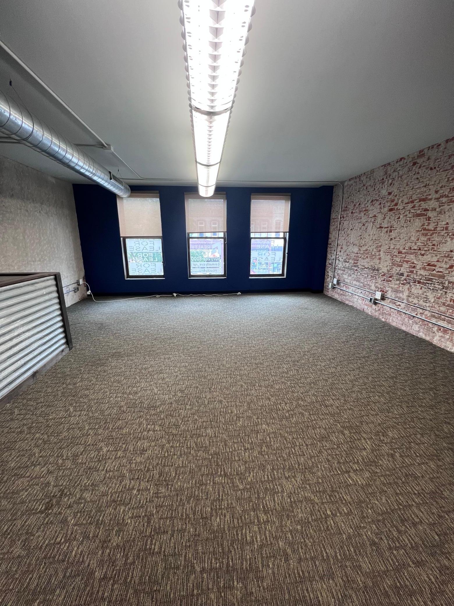 Large open space with exposed brick and large windows.