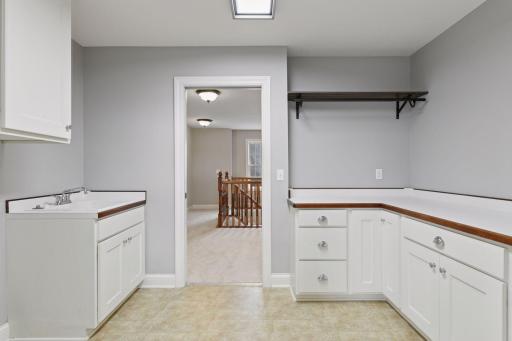 In addition to a spacious walk-in closet, the Primary Suite is adjacent to the upper level Laundry Room which offers plenty of storage cabinetry, a folding counter and laundry sink.