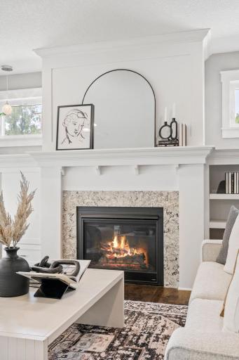 A mantel and built ins surround the gas fireplace.