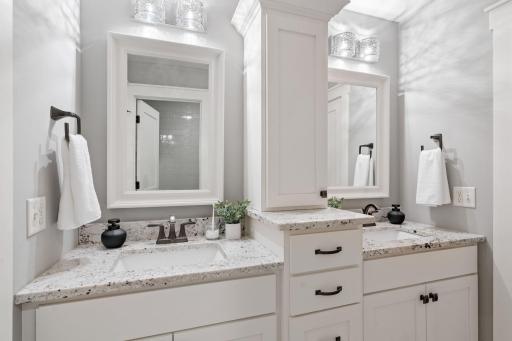 Upstairs full bath with storage space and double vanities.