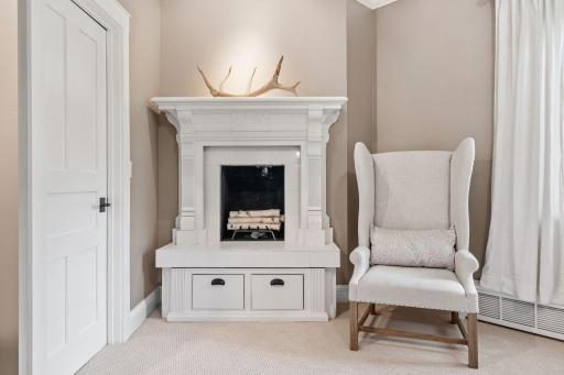 Wood burning fireplace with marble tile surround and antique mantel