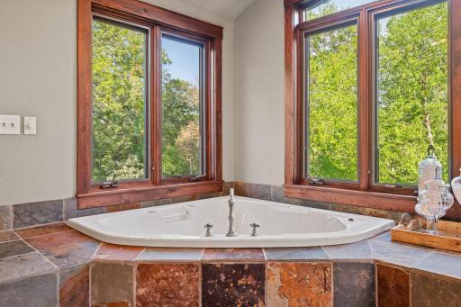 Jetted tub situated on a slate tile deck and surround
