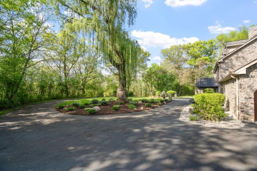 Stone wrapped pillars with lantern lights are carefully placed along the driveway
