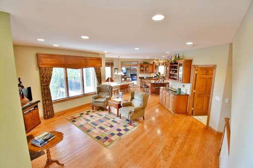 Open sitting area off of living room & neighboring kitchen, views of 2 sided gas fireplace, beautiful hardwood floors.