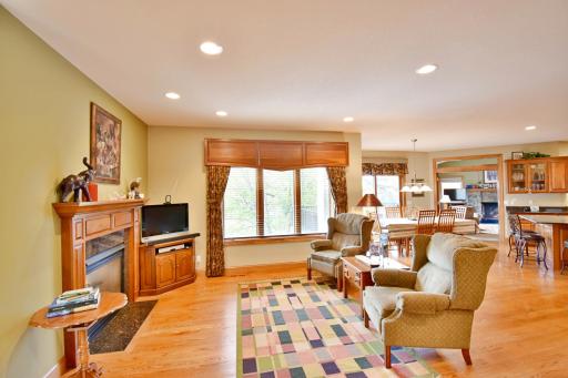 Open sitting area off of living room & neighboring kitchen, views of 2 sided gas fireplace, beautiful hardwood floors.