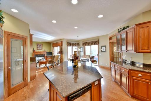 Kitchen island looking back towards walk in pantry, informal dining area, maintenance free deck & sitting area overlooking gas fireplace.