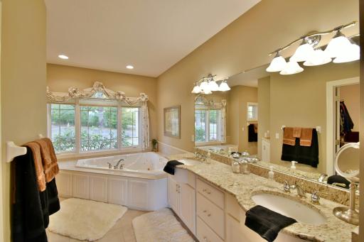 Large on-suite bathroom with 2 person jetted tub, granite counters, dual vanities, neighboring large (12.2x7.4) walk in closet with motion light sensor.