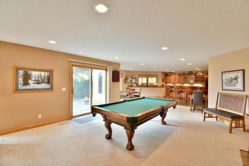 Billiards area overlooking backyard, leading out to back paver patio.