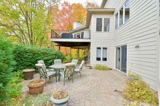Back paver patio space with privacy arborvitae shrubs.