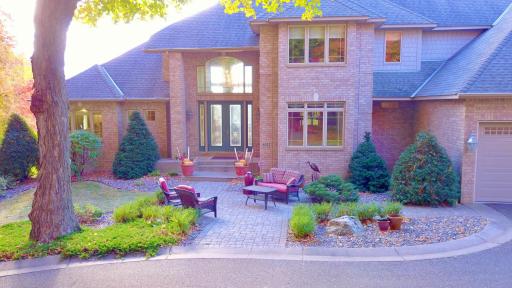 Front paver patio sitting area, professionally landscaped, overlooking mature trees and circle driveway.
