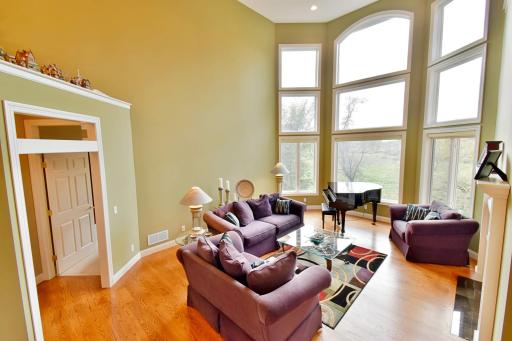 Open & vaulted living room spaces with floor to ceiling windows, double sided gas fireplace, recessed lighting, beautiful hardwood flooring throughout main level. Open concept floor plan.