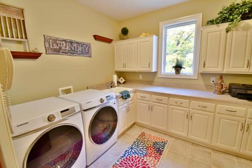 Main level laundry & mudroom with spacious counter space and cupboards for additional storage. Built in tip up/down ironing board.