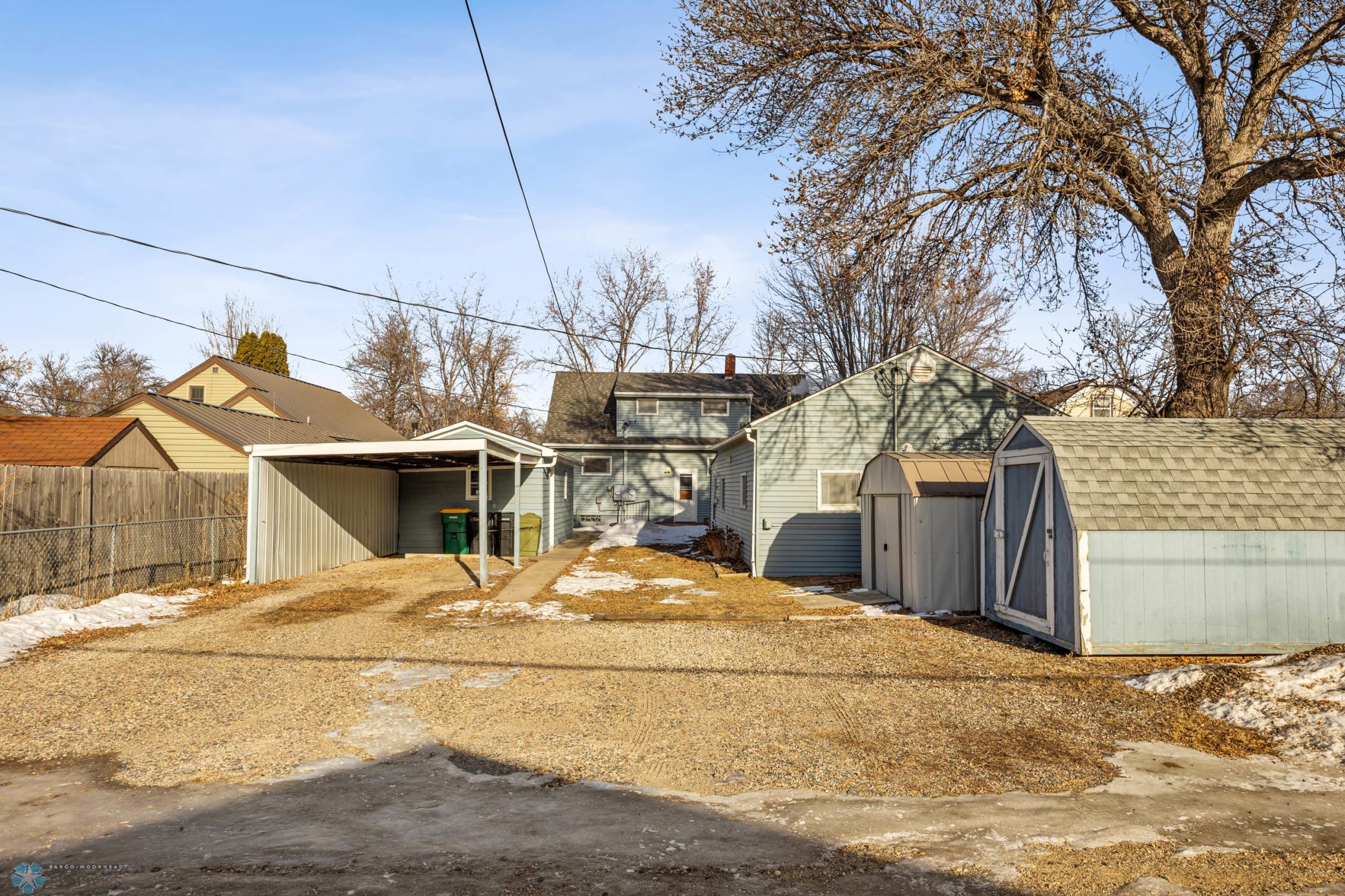 Rear exterior -carport/sheds. Multiple exterior outlets for block heaters. Alley access.