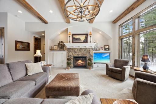 Large family room open to kitchen dining areas. Features include built-in's, stone gas fireplace and beamed ceiling with custom lighting.