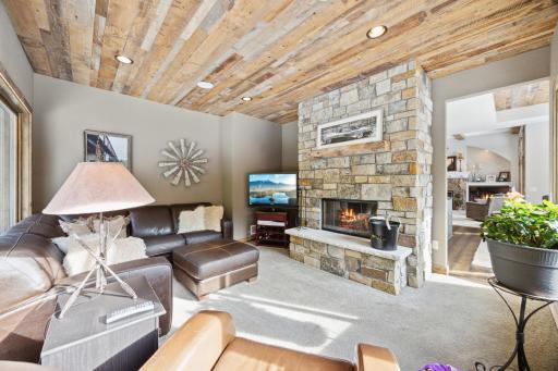 Den or 4 season porch has real wood burning fireplace with custom stone and raised hearth.
