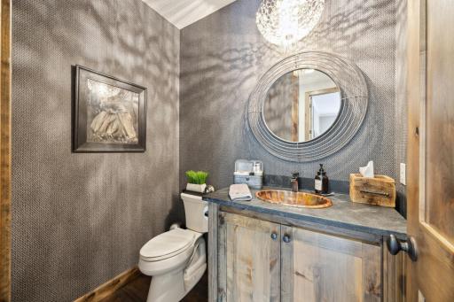 Elegant 1/2 bath off the entry as custom sink and lighting.