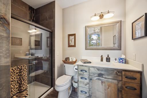 3rd bathroom off 2nd bedroom with tiled shower.