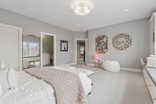 Walk in closet and custom built in cabinetry with window bench