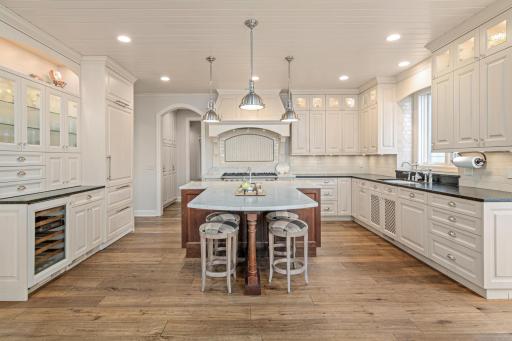 Expansive center island offers seating for casual meals, morning coffee, or reading the paper—surrounded by extensive countertops and abundant custom cabinetry.