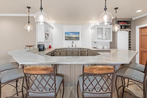 Wow! An incredible horseshoe bar in the lower level, perfect for hosting large parties and gatherings—an entertainer's dream come true. Easily host six people around the bar and more room for those standing.