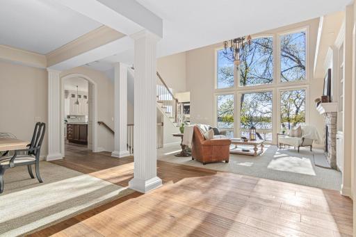 Sundrenched living room with expansive walls of windows offers stunning views of Turtle Lake—an unforgettable first impression the moment you step inside.
