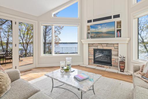 Large patio doors open seamlessly to the oversized deck, making al fresco entertaining effortless while enjoying lakefront living at its finest.