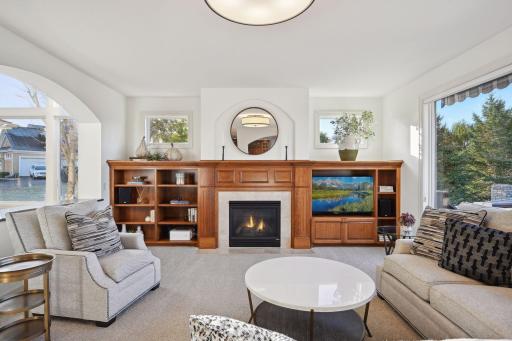 Built-ins surround a gas fireplace and are enhanced by the windows bathing the space with natural light.