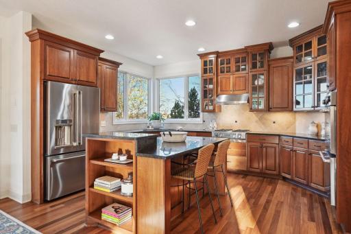 Kitchen is a chef's dream and features double ovens, gas range, microwave (tucked in the center island), dishwasher and refrigerator.