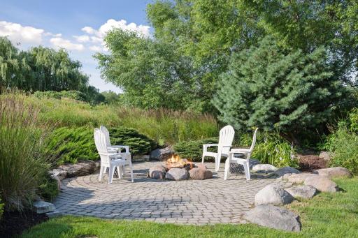 Backyard entertining includes a wood burning fireplace as well as a tucked-away fire-pit.