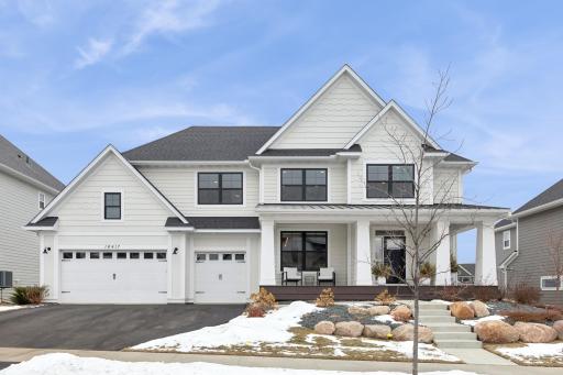Simply beautiful and elegant home! The combination of white trim and black windows and accents gives it a timeless and sophisticated look. The boulder accents around the plants add a natural and earthy touch, creating a nice balance.