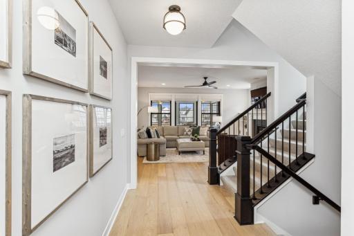The staircase creates an inviting pathway that guides you from the hallway into the warmth of the great room and the heart of the kitchen.