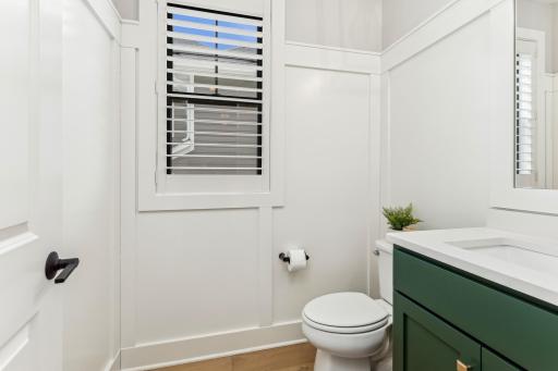 This conveniently located half-bathroom is situated on the main floor in the central hallway, offering easy access for both residents and guests. The space is bright and well-lit, with clean white trim and modern finishes.