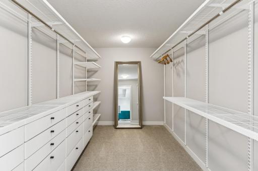 In this well-designed walk-in closet, custom-built drawers glide smoothly, providing organized storage for folded clothes and accessories