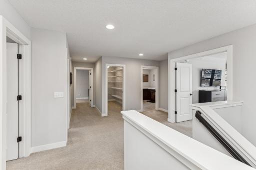 The upper-level hallway seamlessly connects living spaces. It provides access to the bedrooms, features a walk-in storage closet for items you use periodically, and conveniently leads to the upper-level laundry