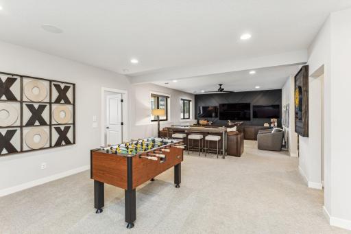 The gaming area and wet bar open up to the sport court, creating a seamless transition between relaxation and active play.