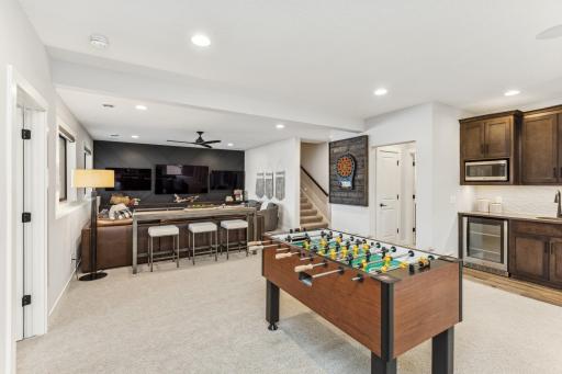 The gaming area and wet bar seamlessly flow into the sport court, creating an ideal setup for both relaxation and active fun. This thoughtful design ensures that entertainment and recreation are always within easy reach.