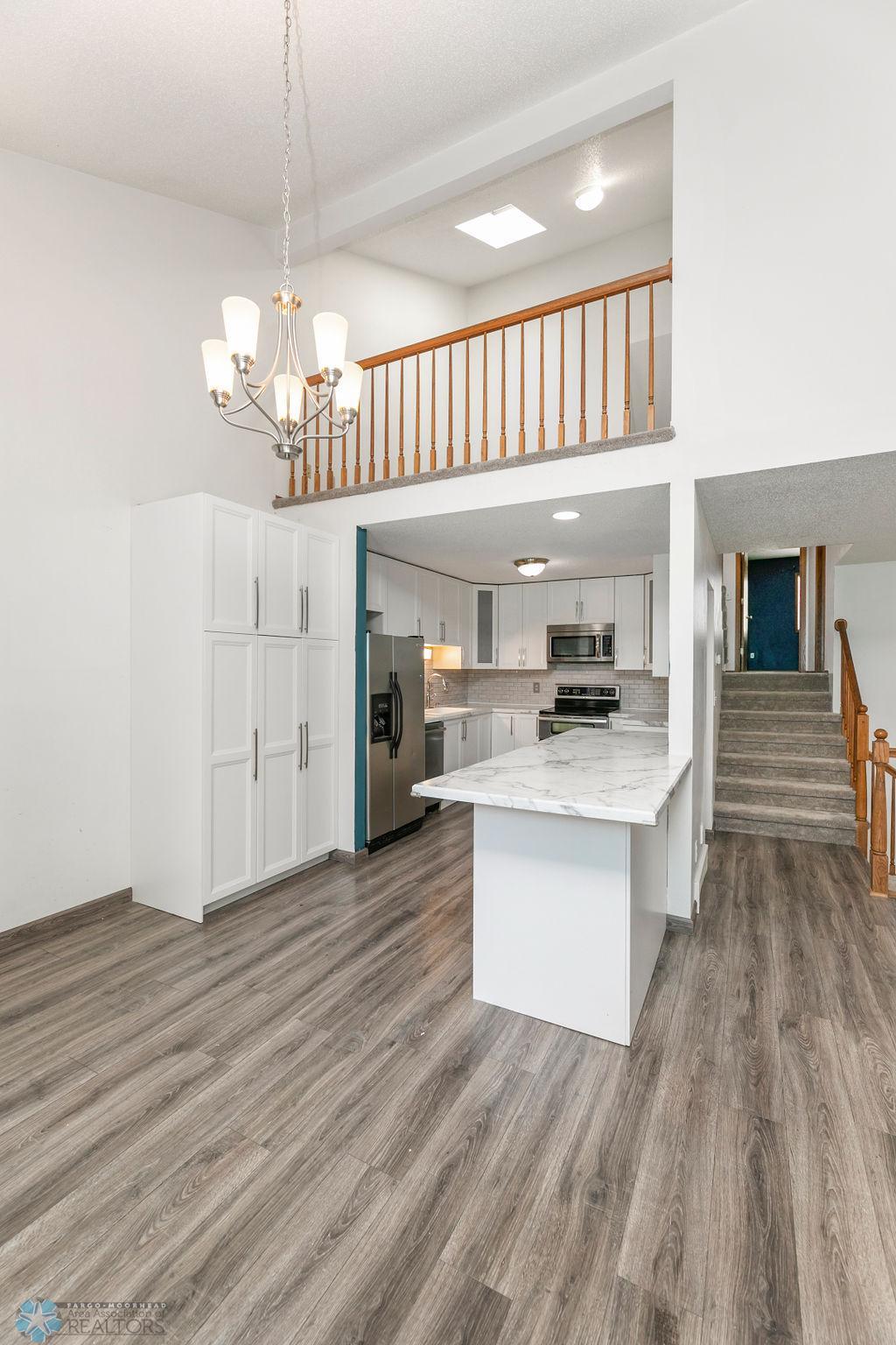 Kitchen offers peninsula w/ seating, pantry, & stainless appliances