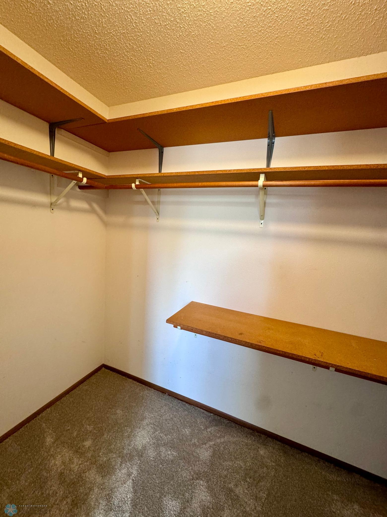 Bedroom 2's WIC w/ hanging storage & shelves