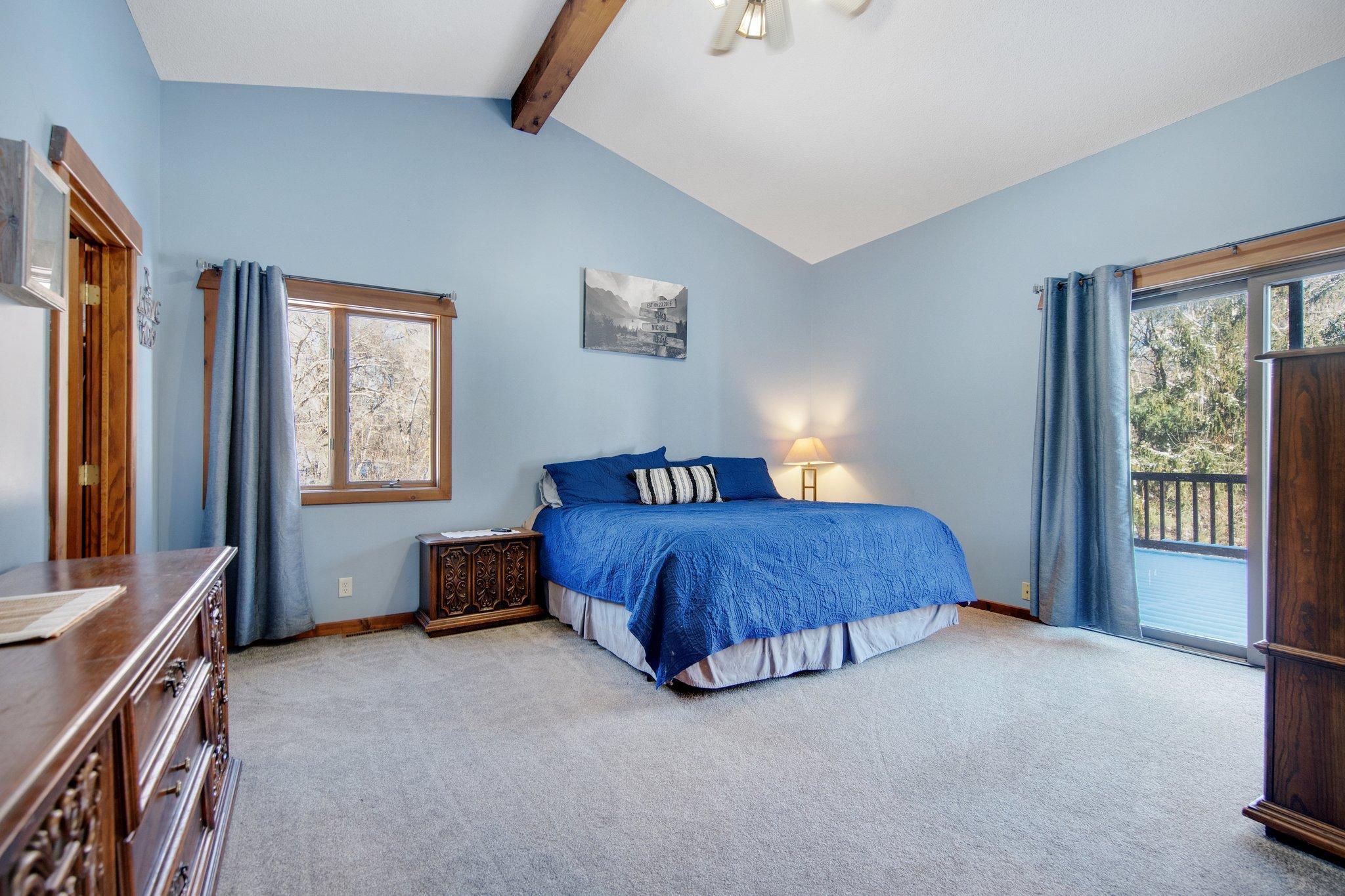 Primary bedroom on the upper level with sliding door to the deck. Huge walk-in closet too!