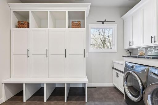 expansive mudroom laundry room with custom lockers and shelving, farm style sink and plenty of storage