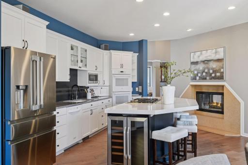 expansive center island, wine fridge and cozy fireplace make cooking a joy