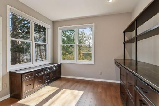 main level corner office with custom cabinetry and stunning granite countertops, built in file cabinets and walls of windows