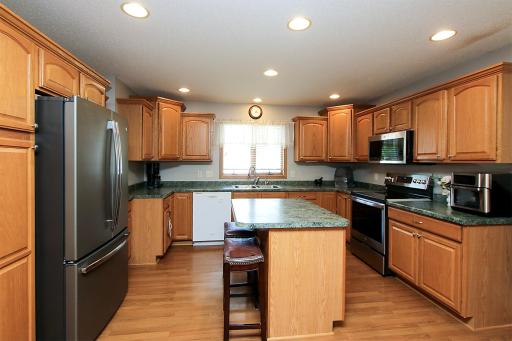 The kitchen features warm oak cabinets, a center island, S.S. appliances, and a pantry cabinet.