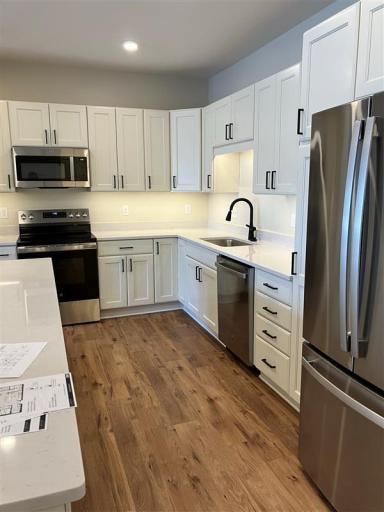 The open-concept kitchen serves as the heart of the home, featuring a spacious center island with stunning quartz countertops, perfect for meal preparation, casual dining, or entertaining guests.