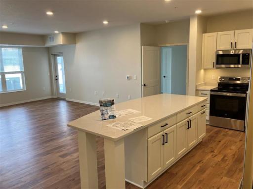 The large living room is bathed in natural light, offering flexible layout options and direct access to a screened-in maintenance-free deck, where you can relax and enjoy the outdoors in comfort year-round.